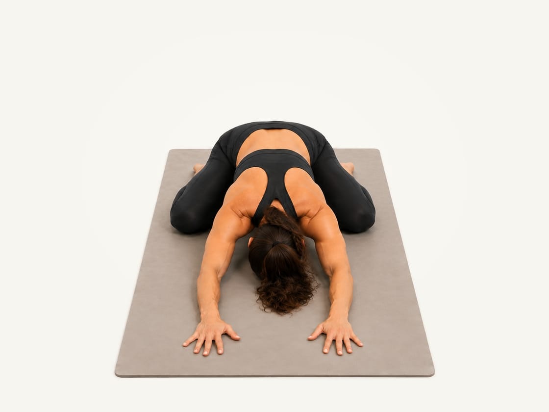 Child's pose: kneeling with the hips eased back towards the heels, arms long in front, forehead on the mat