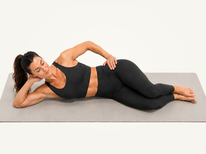 Step 1 of clamshells: lying on the right side, head on the right arm, hips, knees and feet stacked