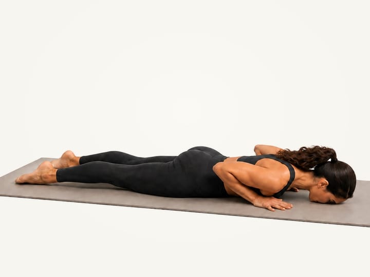 Step 1 of cobra pose: lying face down, palms beside the ribs, elbows close to the sides
