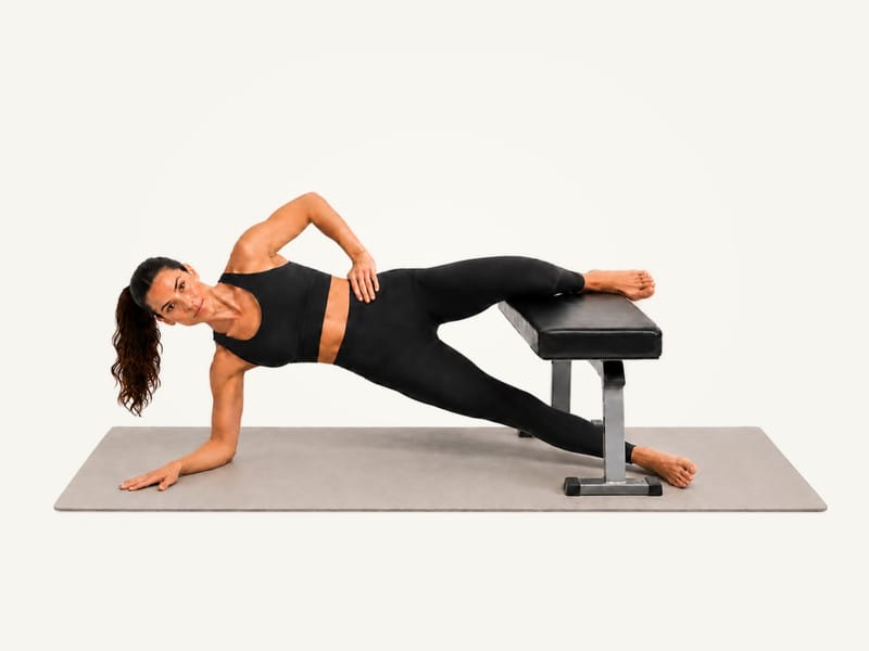 Copenhagen plank set-up: on the right forearm, left knee on the bench, lower right foot on the floor