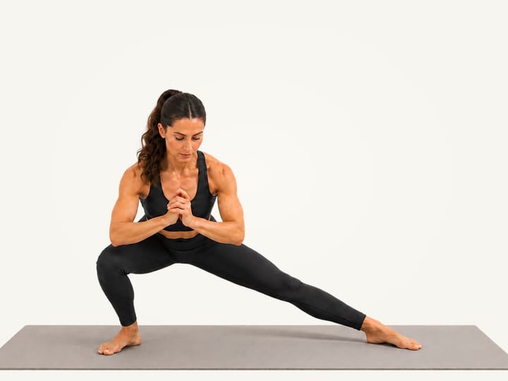Step 2 of the Cossack squat: weight shifted onto the bending right leg, left leg straight