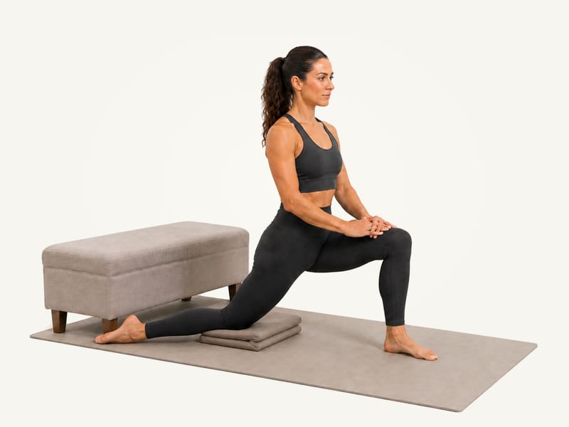 Couch stretch set-up: right knee on a folded cushion in front of a low bench, left foot forward