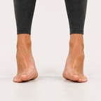 Lateral foot rocks: close-up of both feet rolling towards their outer edges