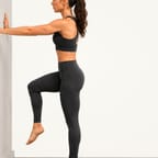 Single-leg balance: standing on one leg with a hand resting lightly on a wall